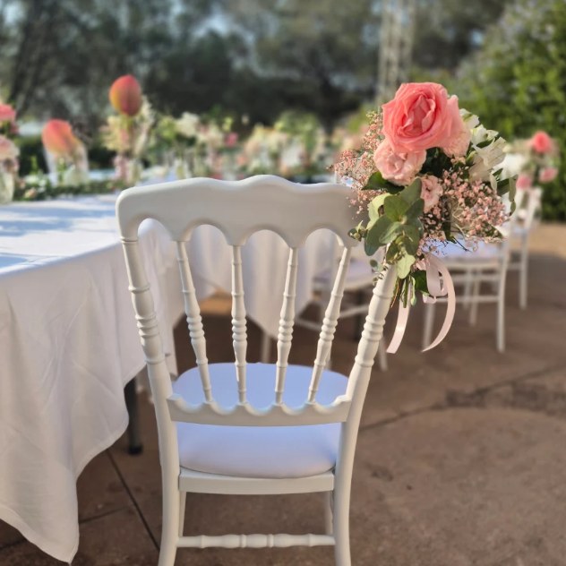Photo de l'avis : une chaise de mariage blanche ornée d'un bouquet de roses