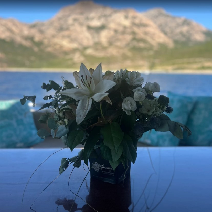 Photo de l'avis : un bouquet de lys et de roses blanches dans un vase Sperenza, sur un yacht face aux montagnes corses